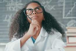 girl in lab coat in front of blackboard